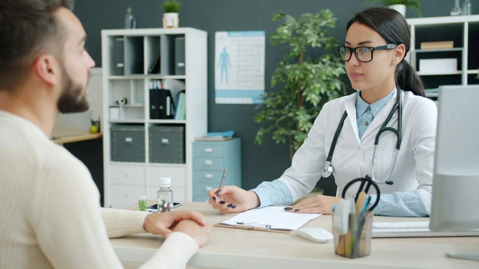 A doctor talking with a patient during a consultation in a bright office